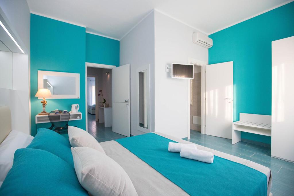 ein blau-weißes Schlafzimmer mit einem großen Bett in der Unterkunft B&b Olas Del Mar in Cefalú