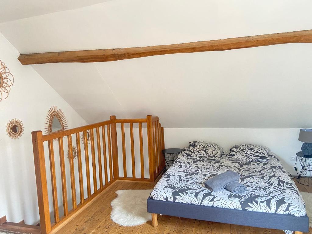 1 dormitorio con 1 cama y 1 cuna de madera en La petite maison solognote, en La Ferté-Saint-Aubin