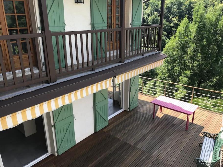 a balcony with a pink bench on a house at Charming cottage, 10 minutes from Ax les Thermes in Unac