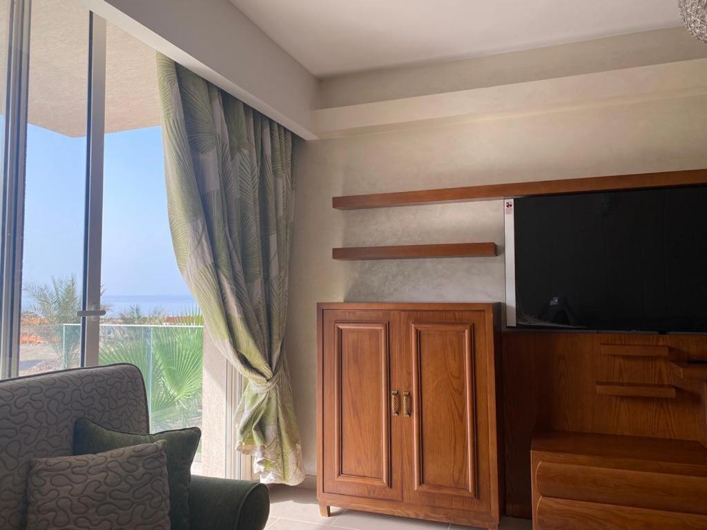 a living room with a flat screen tv and a large window at Il monte galala in Ain Sokhna