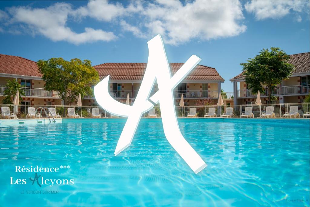 a sign in the swimming pool at a resort at Résidence les Alcyons in Le Verdon-sur-Mer