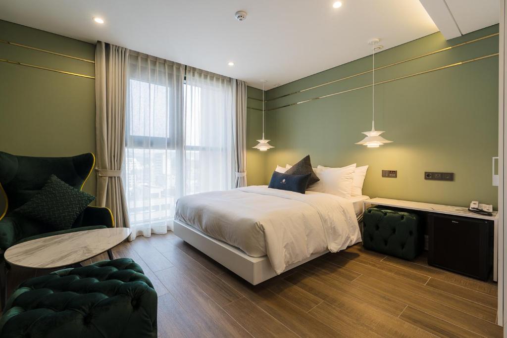 um quarto com uma cama, uma cadeira e um sofá em HOTEL THE MAY Jongno em Seul