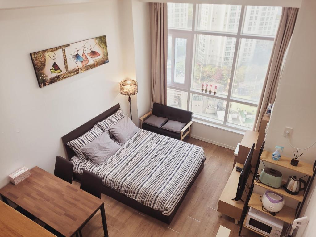 uma pequena sala de estar com uma cama e uma mesa em Travel House em Seul