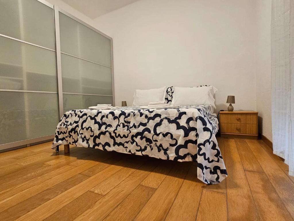 een slaapkamer met een bed met een zwart-witte deken bij Alloggio Desiri in Pavia