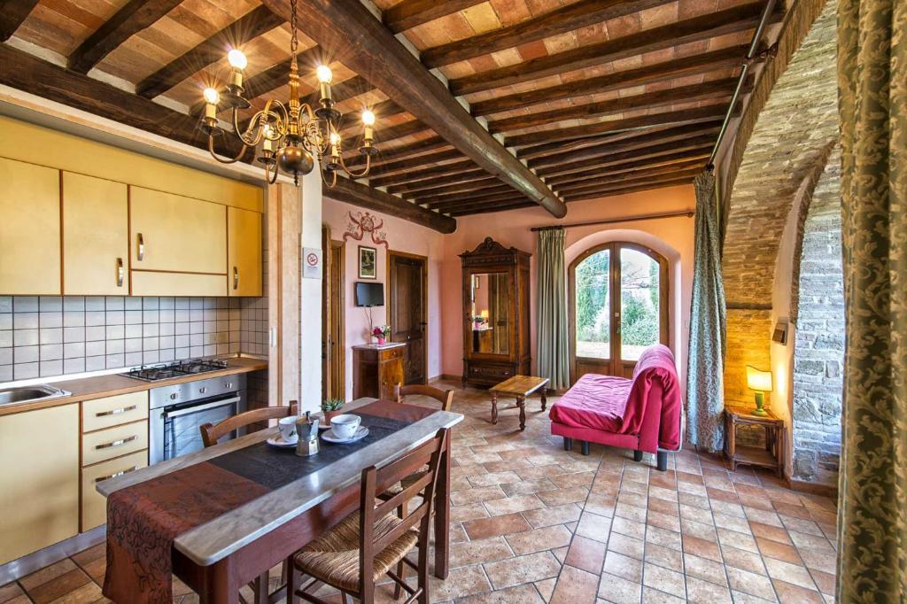 a kitchen with a table and chairs in a room at Croce di mezzo in Montalcino