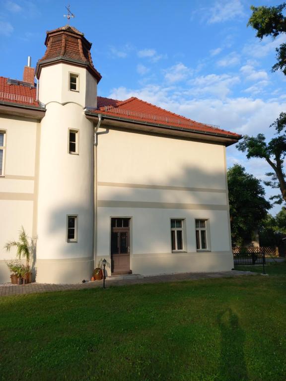 a white house with a red roof at Ferienwohnung Gutshaus Klitzschen in Mockrehna