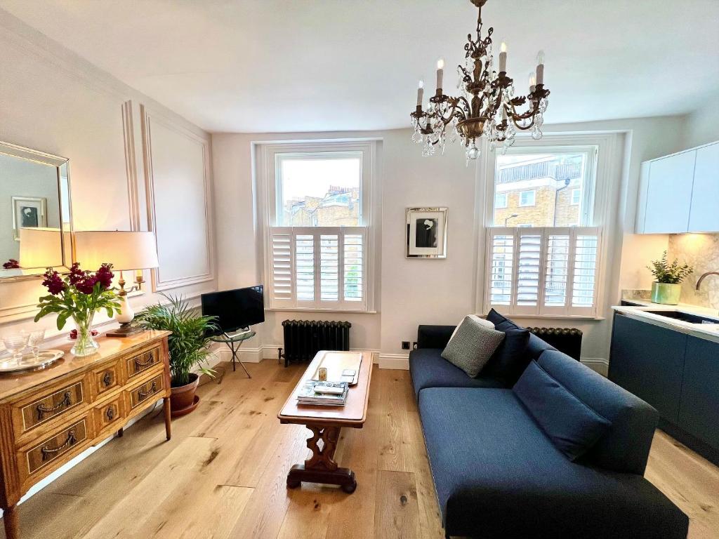 a living room with a blue couch and a table at Luxury flat on Fulham/Chelsea border in London