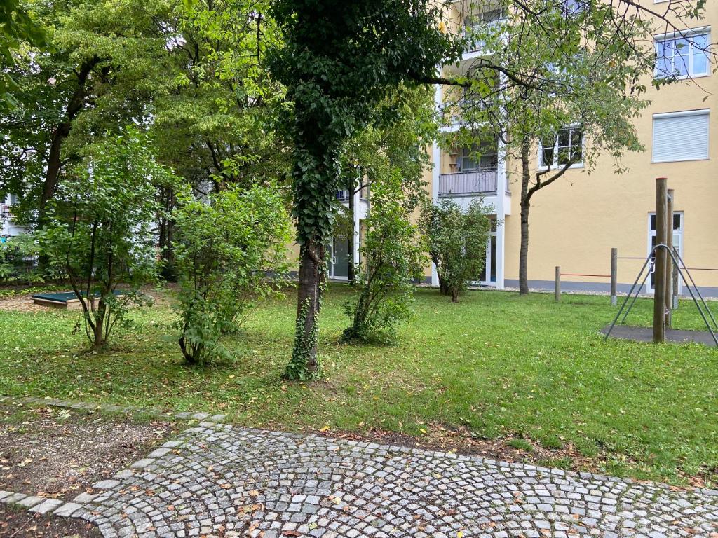 a park with trees in front of a building at Bayern Lodge München in Munich