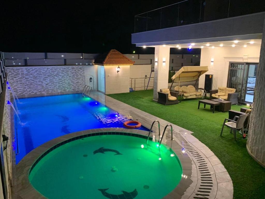 uma piscina no meio de um quintal à noite em Sea view chalet em Taba