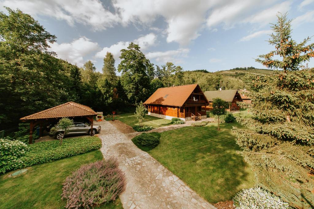 a house with a car parked in front of a yard at Cabin Sonka in Oščadnica