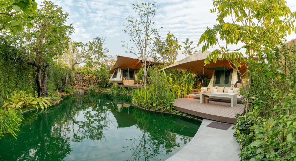 uma casa com um lago em frente em CAMP CAYLA - EDEN em Chiang Mai