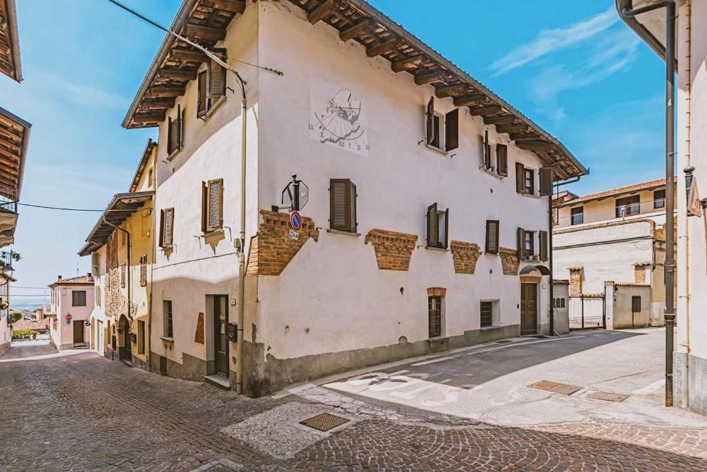 un gran edificio blanco con ventanas en una calle en Casa Lobe - Charming apartment in village centre, en La Morra