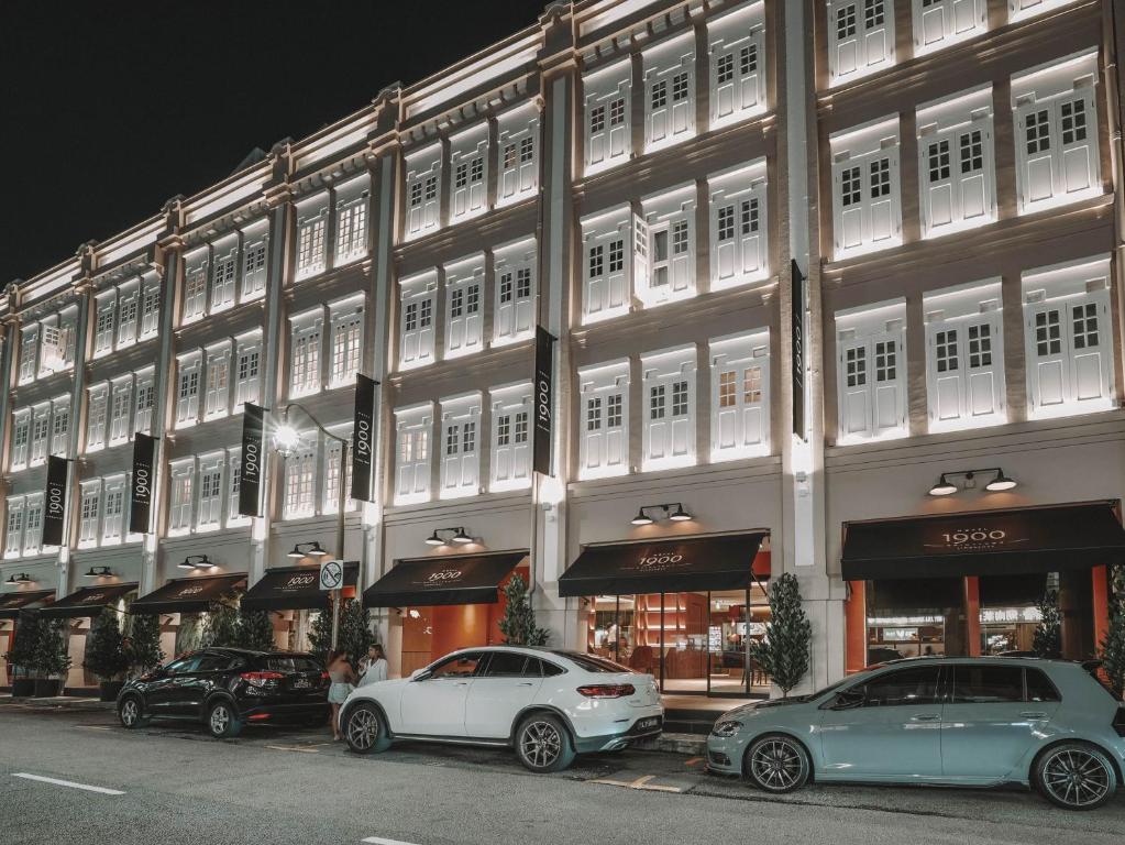 dois carros estacionados em frente a um edifício em Hotel 1900 Chinatown em Singapura