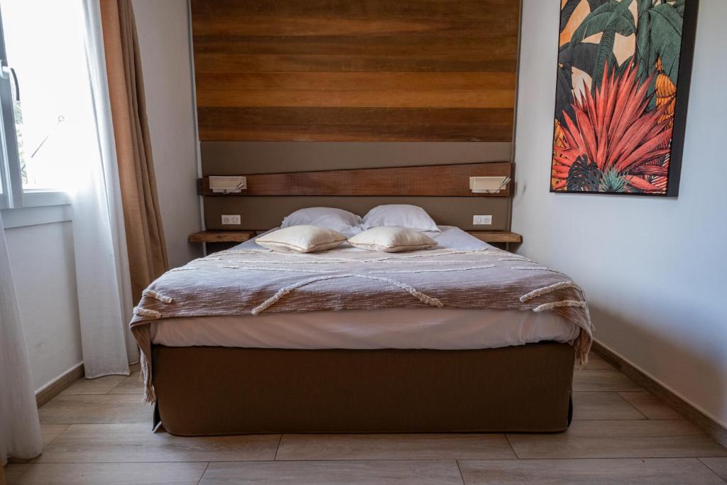 a bed with two pillows on it in a bedroom at Hôtel & Restaurant Les Mouettes in Belgodère
