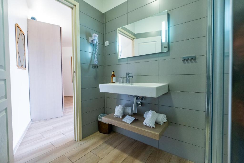 a bathroom with a sink and a mirror at Hôtel & Restaurant Les Mouettes in Belgodère