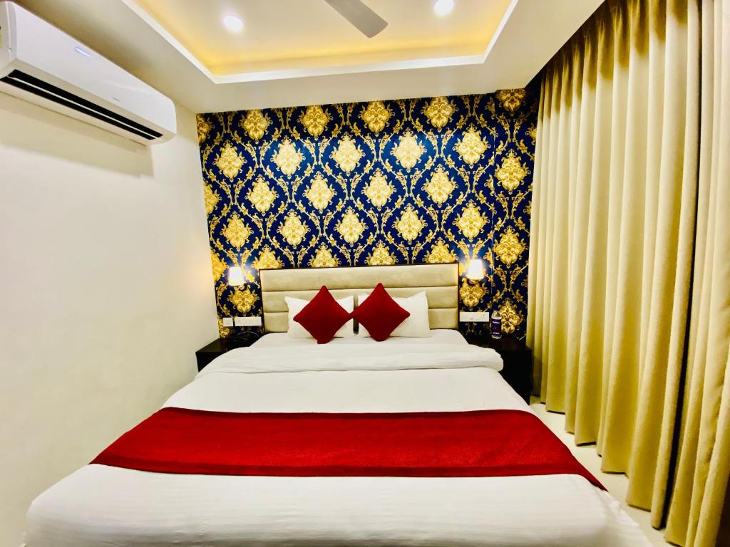 a bedroom with a large bed with red pillows at Blueberry Hotel zirakpur-A Family hotel with spacious and hygenic rooms in Chandīgarh