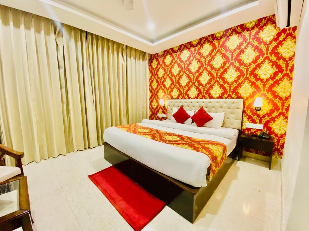 um quarto com uma cama e uma parede vermelha em Blueberry Hotel zirakpur-A Family hotel with spacious and hygenic rooms em Chandīgarh