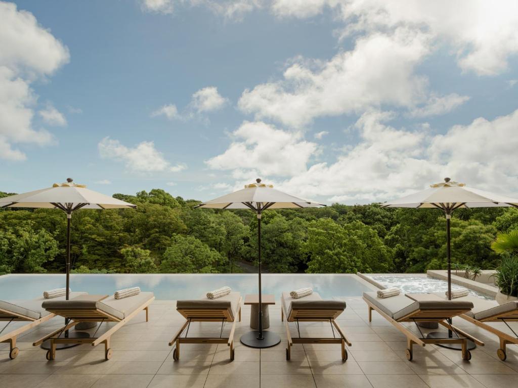 a patio with chairs and umbrellas and a pool at TRUNK(HOTEL) YOYOGI PARK in Tokyo