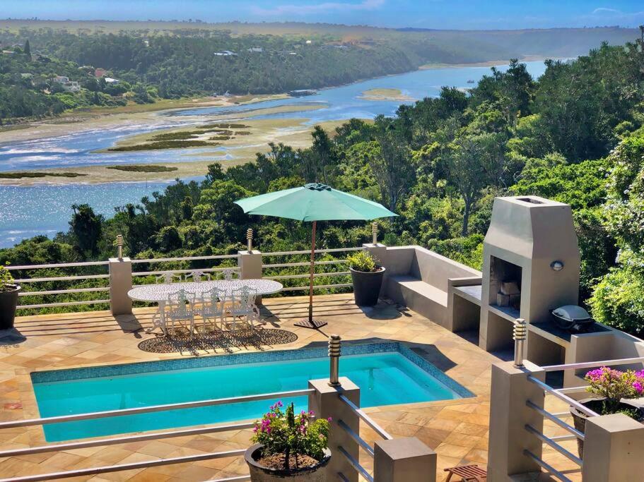 a villa with a pool and a view of the ocean at Bushmans River Lodge in Kenton on Sea