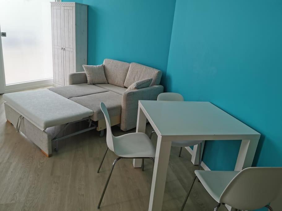ein Wohnzimmer mit einem Sofa, einem Tisch und Stühlen in der Unterkunft Apartment in Natrup-Hagen 