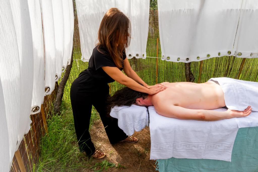 a woman is giving a man a massage at Hôtel & Restaurant Les Mouettes in Belgodère