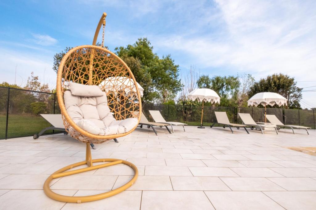 a wicker chair sitting on a patio at Hôtel & Restaurant Les Mouettes in Belgodère