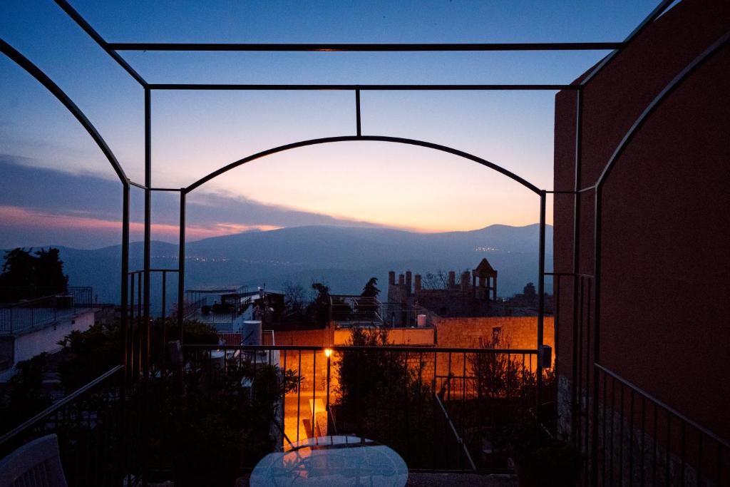einen Blick auf den Sonnenuntergang vom Balkon eines Gebäudes in der Unterkunft Artists Colony Inn Zefat in Safed