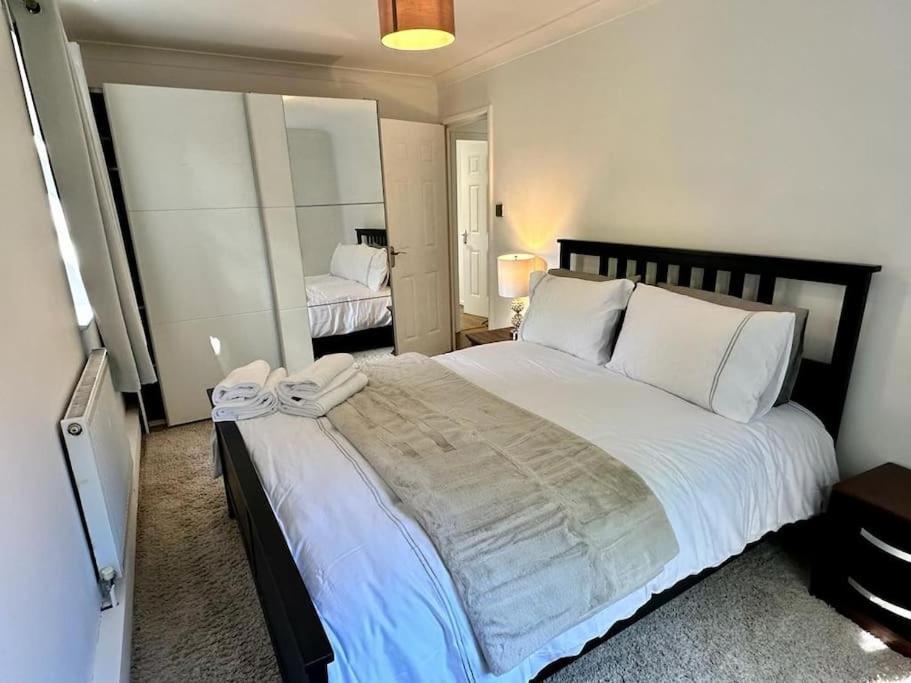 a bedroom with a large bed with white pillows at Spacious 2-bed flat with free parking in Croydon