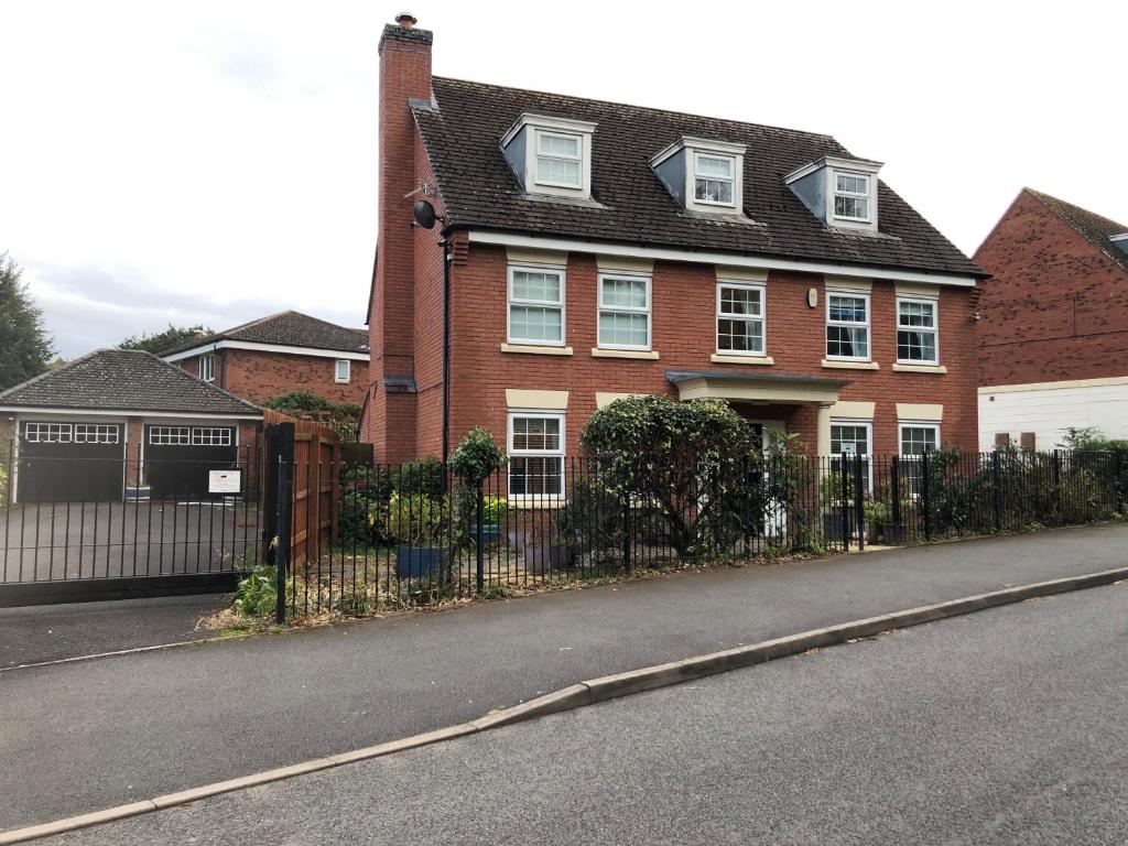 a red brick house with a black fence at Cherry Tree house in Wellington