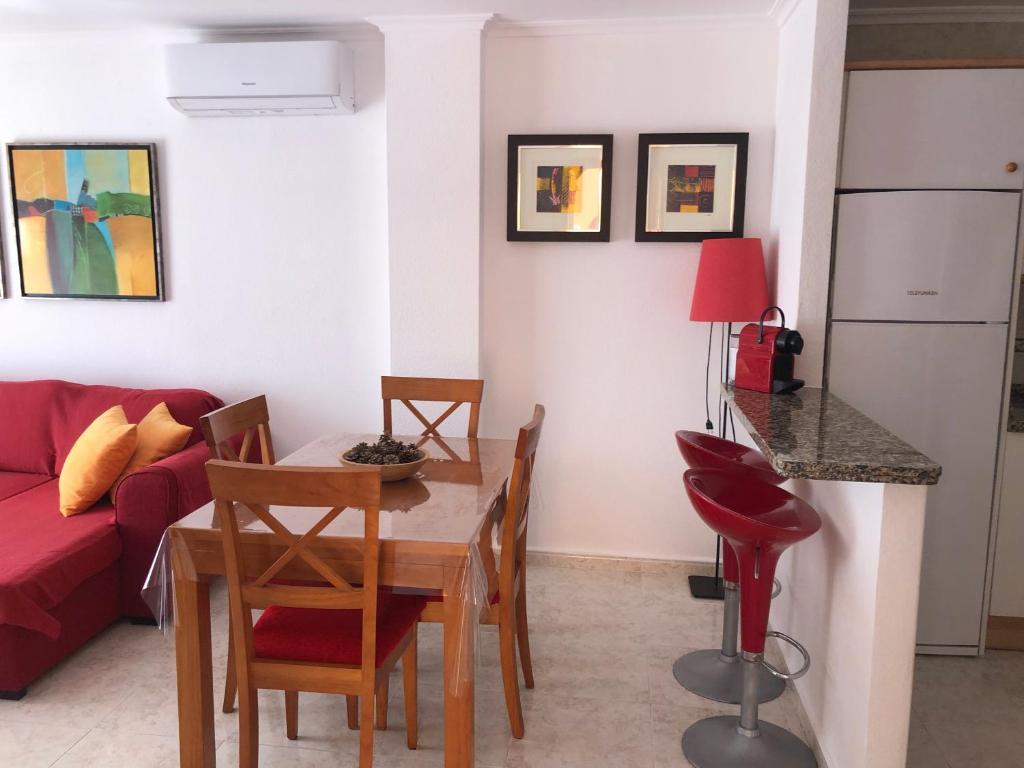 a living room with a table and a red couch at Paraíso in Cumbre del Sol