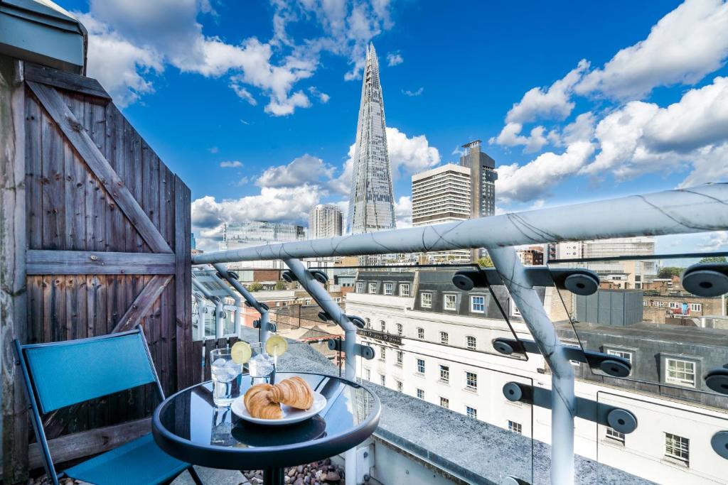 a table and chairs on a balcony with a view of the city at London Bridge Penthouse - Luxury in London