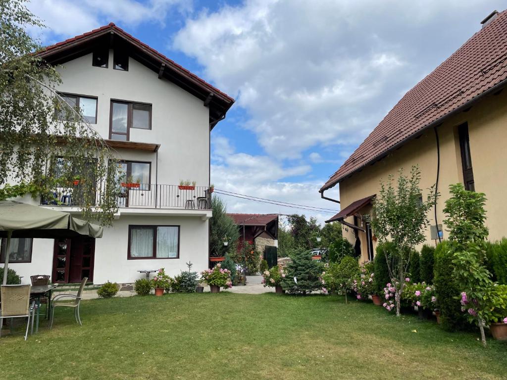 ein Haus mit Rasen davor in der Unterkunft Casa Piscu Ioanei in Braşov