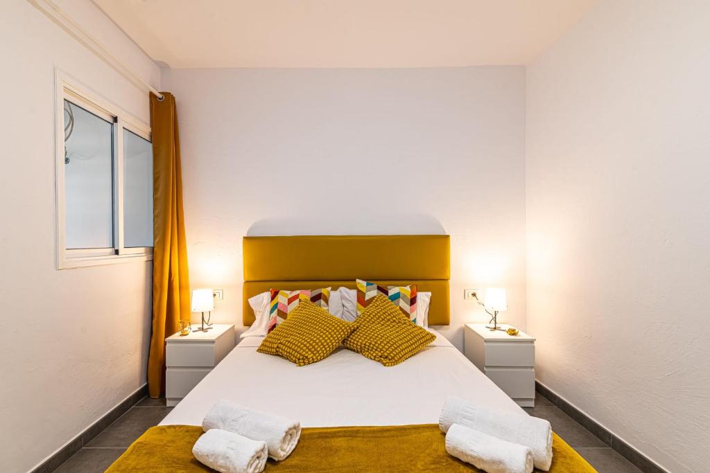 a bedroom with a large white bed with yellow pillows at Acogedor apartamento en La Listada cercano a la Playa by Alterhome in La Listada