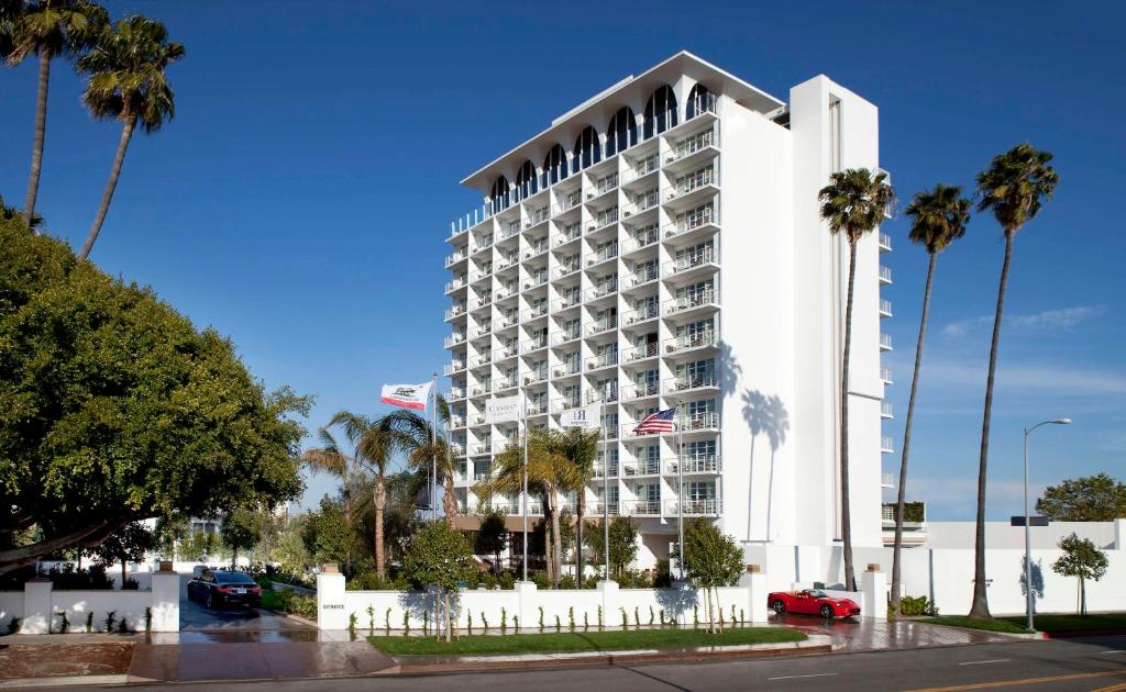ロサンゼルスにあるCameo Beverly Hillsのヤシの木が目の前に広がる白い大型ホテル