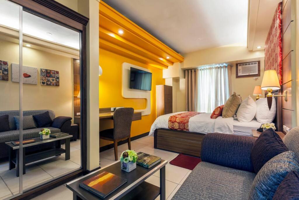 a hotel room with a bed and a living room at Tivoli Garden Residences - Iris Tower in Manila