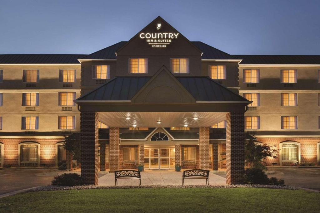 un hotel con due panchine di fronte a un edificio di Country Inn & Suites by Radisson, Lexington, VA a Lexington