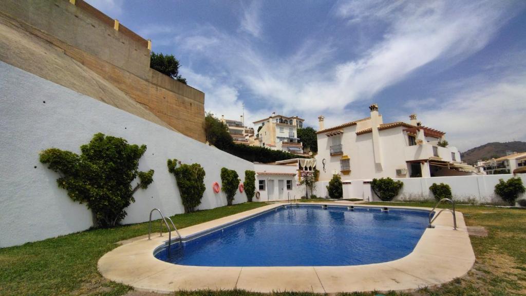 a swimming pool in the yard of a house at Apartamento Bambadela in Cala del Moral