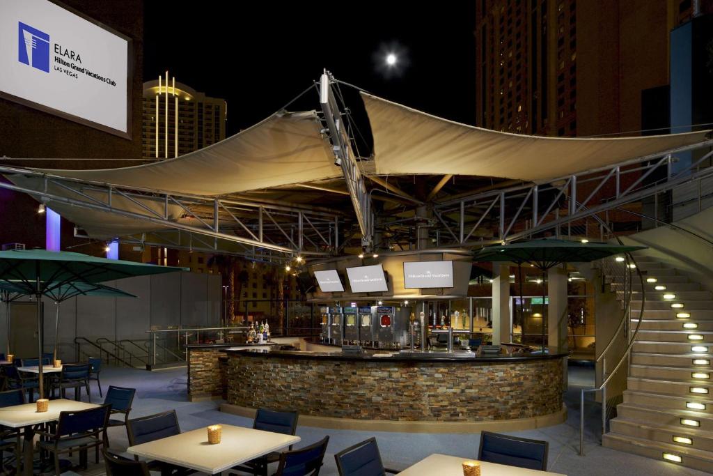 ein Restaurant mit einer Bar mit Tischen und Stühlen in der Unterkunft Hilton Club Elara Las Vegas in Las Vegas