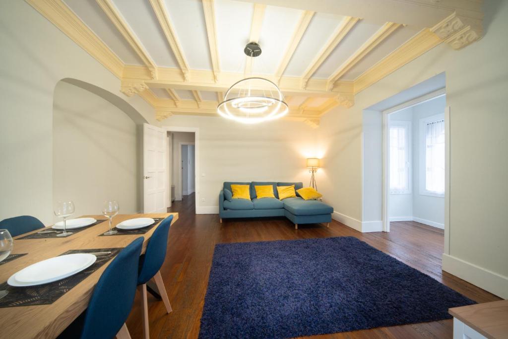 sala de estar con mesa y sofá azul en Apartamento con garaje en el centro de Zumaia en Zumaia