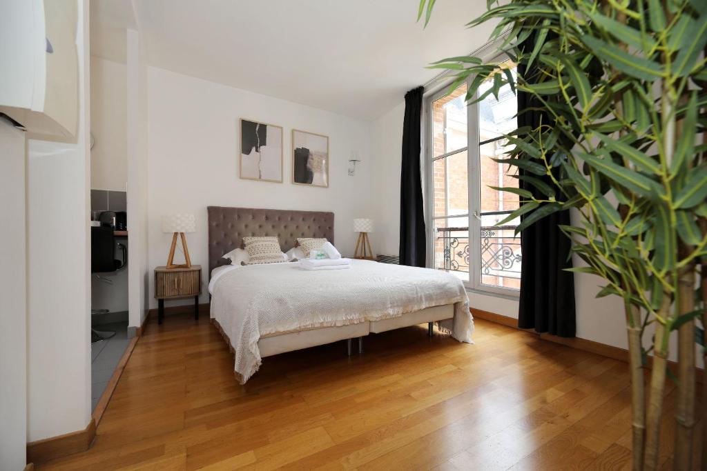 a bedroom with a bed and a large window at 303- Relaxez vous dans un studio de charme Paris 5 in Paris