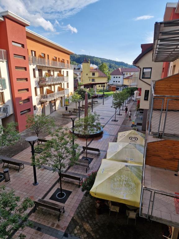 eine Stadtstraße mit Tischen, Bänken und Gebäuden in der Unterkunft Apartmán Borgi in Oščadnica