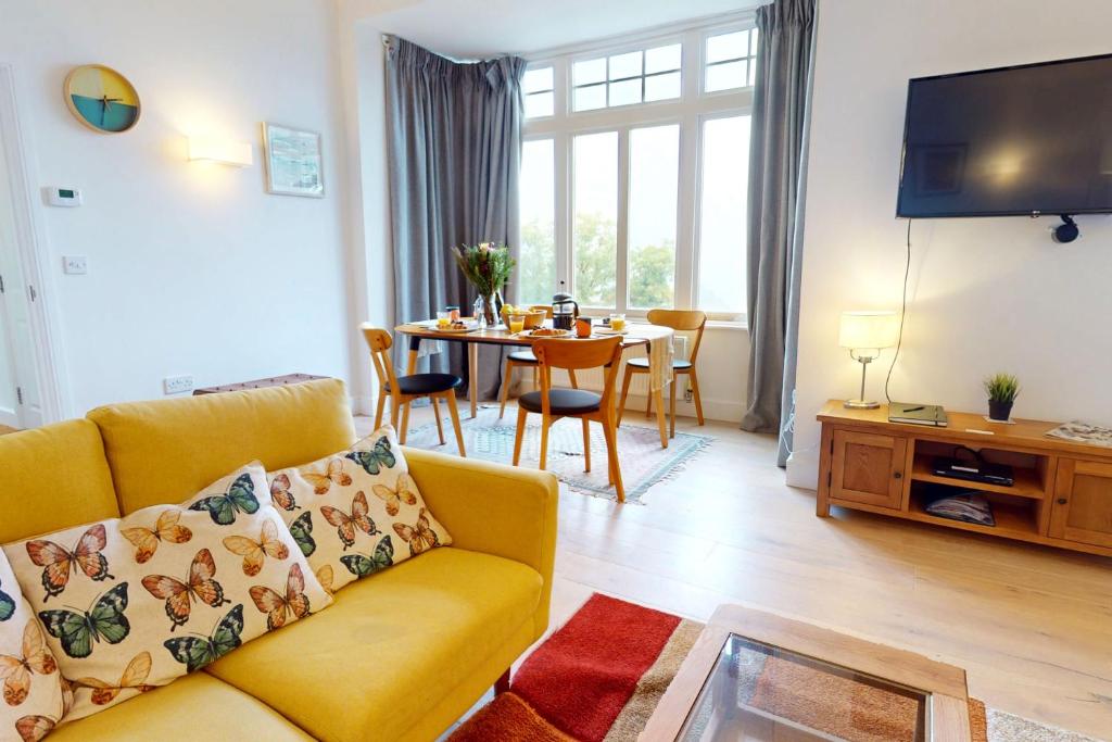 uma sala de estar com um sofá e uma mesa em WOODY BAY FALLING WATER 2 Bedrooms em Lynton