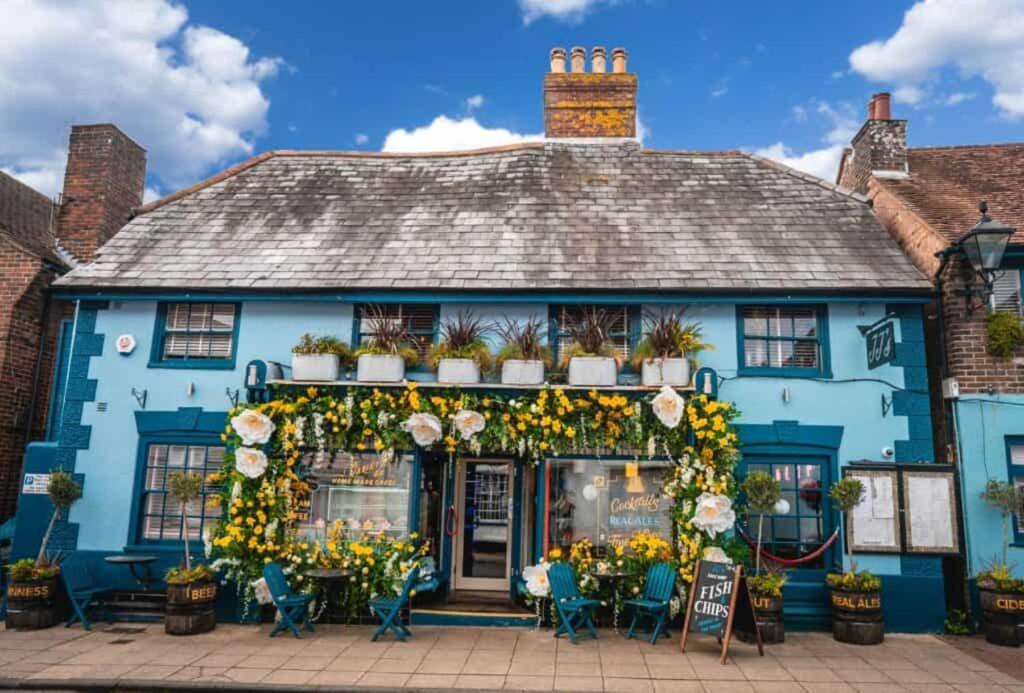 un edificio azul con flores delante en Kip 23 JJs Emsworth en Emsworth