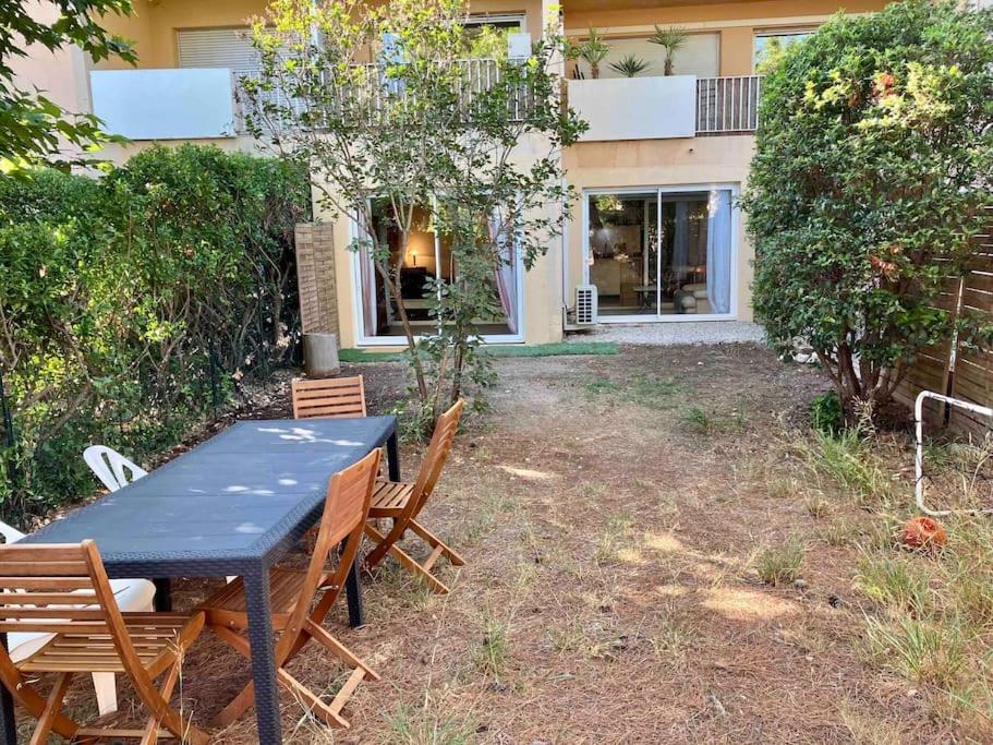 une table et des chaises devant une maison dans l'établissement Appartements 2 chambres, grand jardin et parking, à Aix-en-Provence