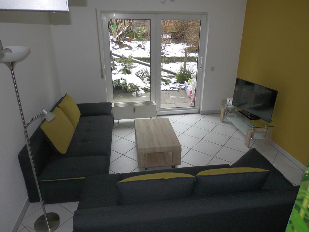 a living room with a blue couch and a table at Ferienwohnung Wehr in Filderstadt