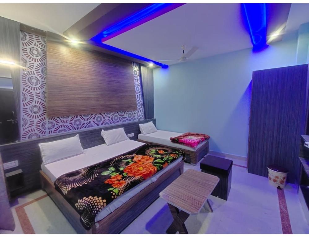 Un dormitorio con una cama y un sofá con flores. en Hotel Anuj Residency, Chitrakoot en Sītāpur Mūāfi