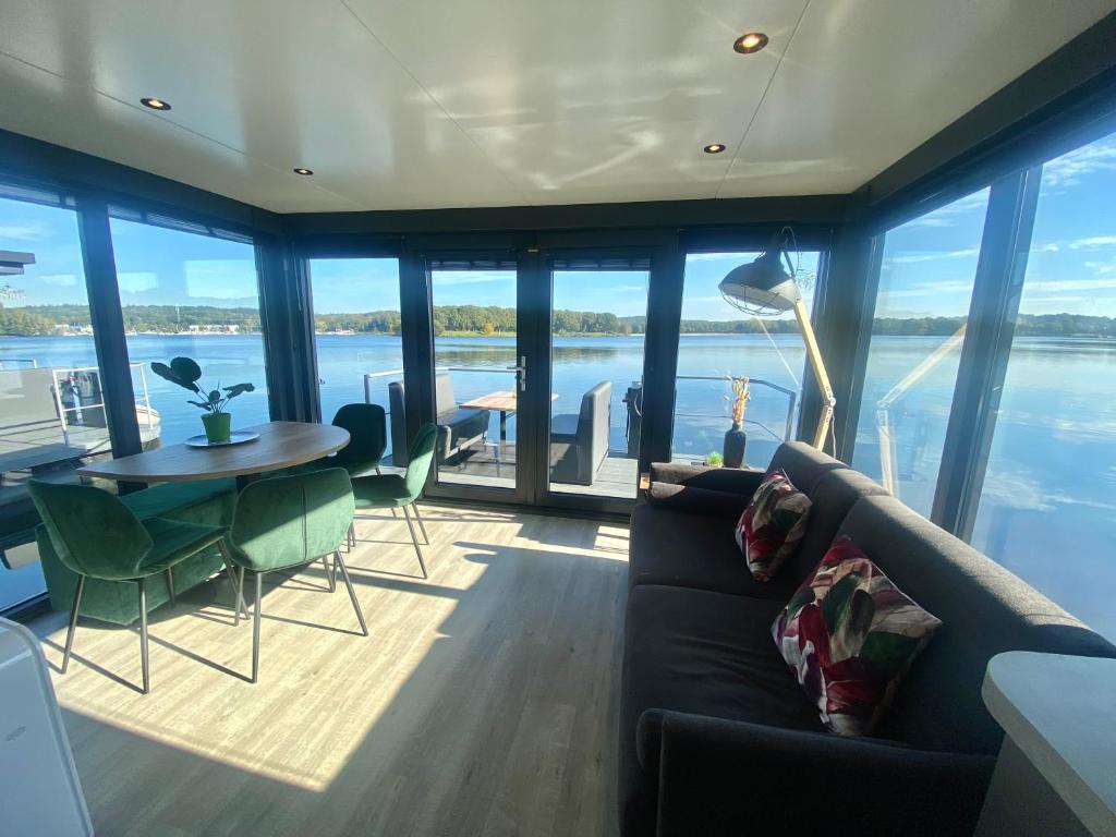 een woonkamer met een bank en een tafel bij Houseboats Mookerplas in Middelaar