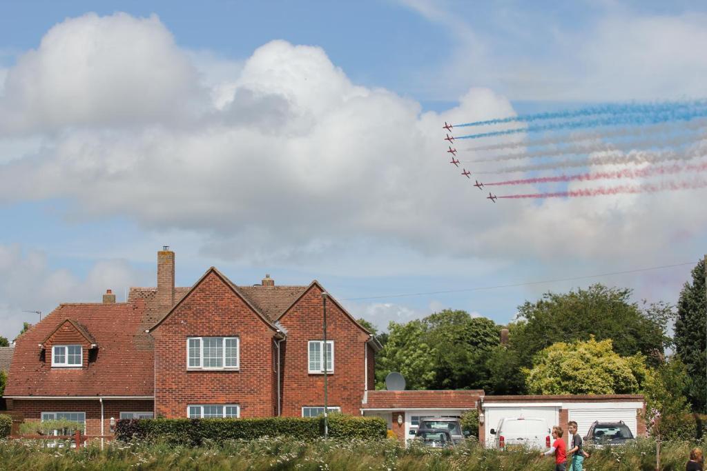 a kite flying in the sky over a house at Goodwood Chichester, (more interior pics coming) in Tangmere