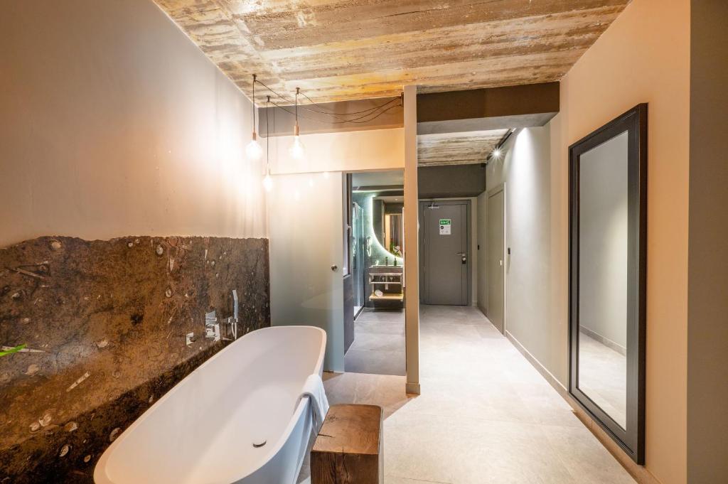 a bathroom with a bath tub and a mirror at Salini Suites in Żebbuġ