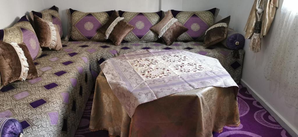 een bed met veel kussens in een kamer bij alloggio in Agadir